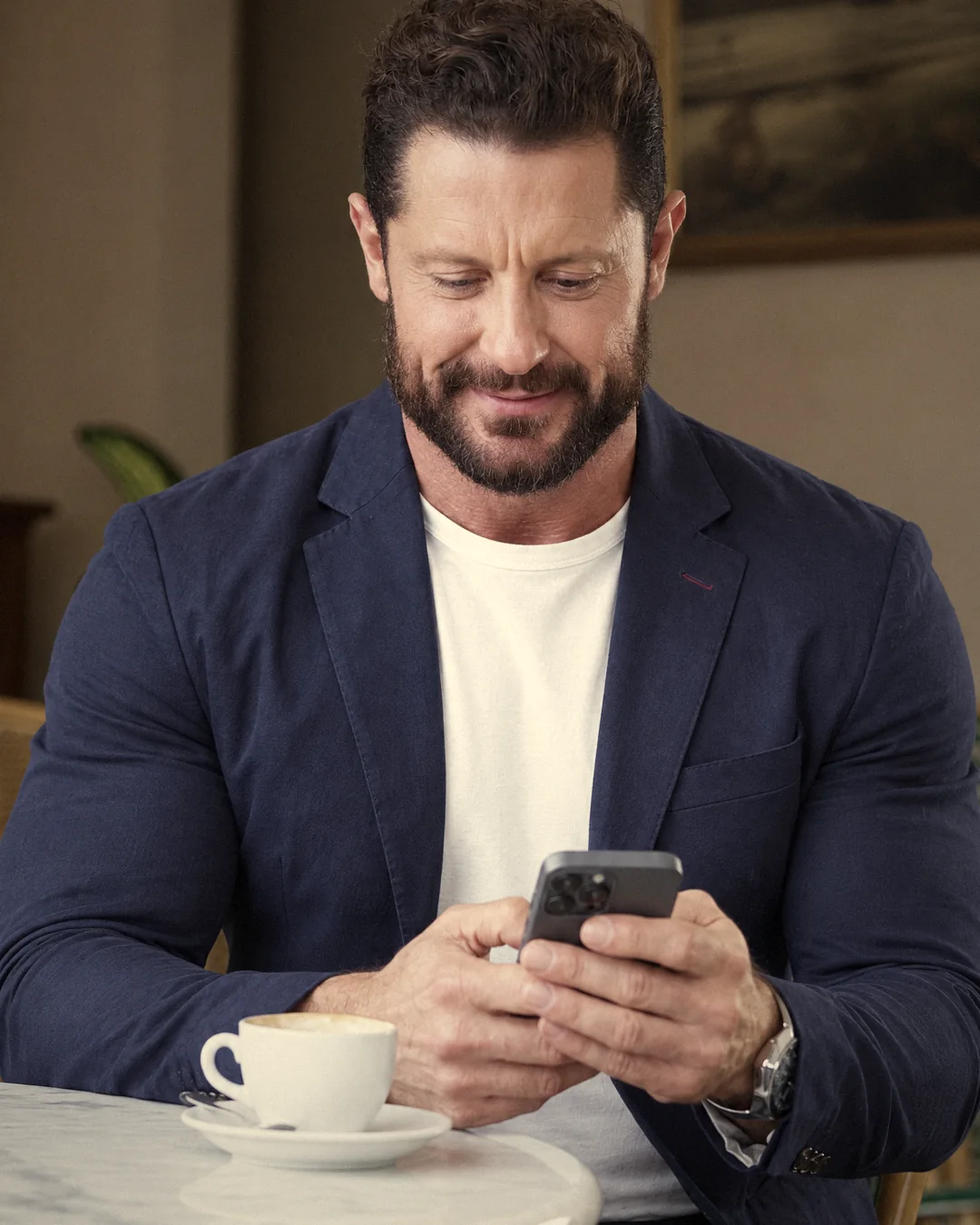 Giuseppe Notarnicola al tavolino di un caffè, con il telefono in mano
